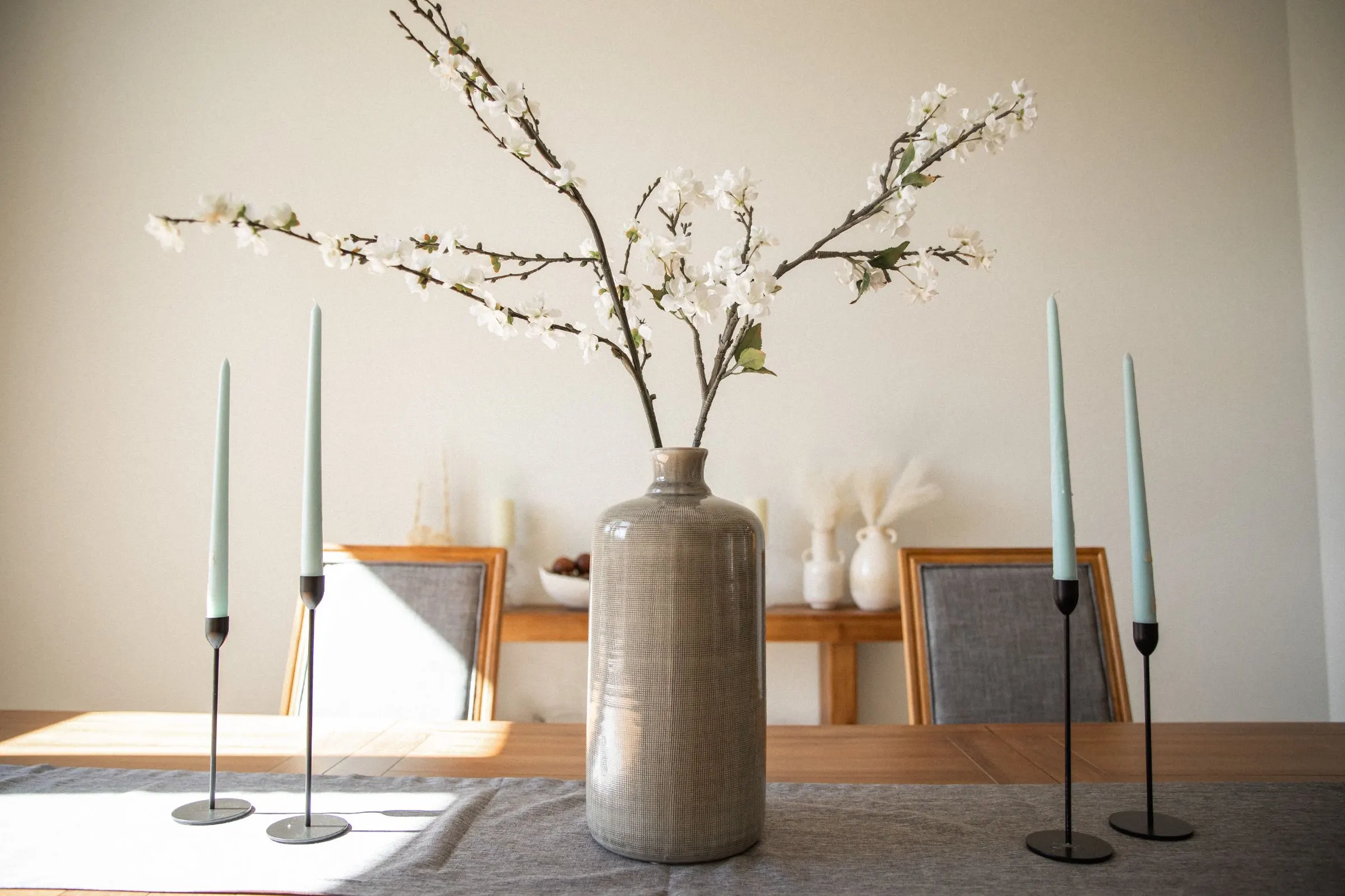 Blossoming branches in a stoneware vase in soft light